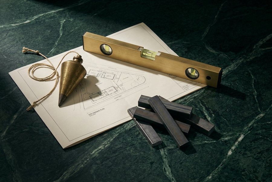 Brass plumb bob and spirit level resting on a folded site drawing